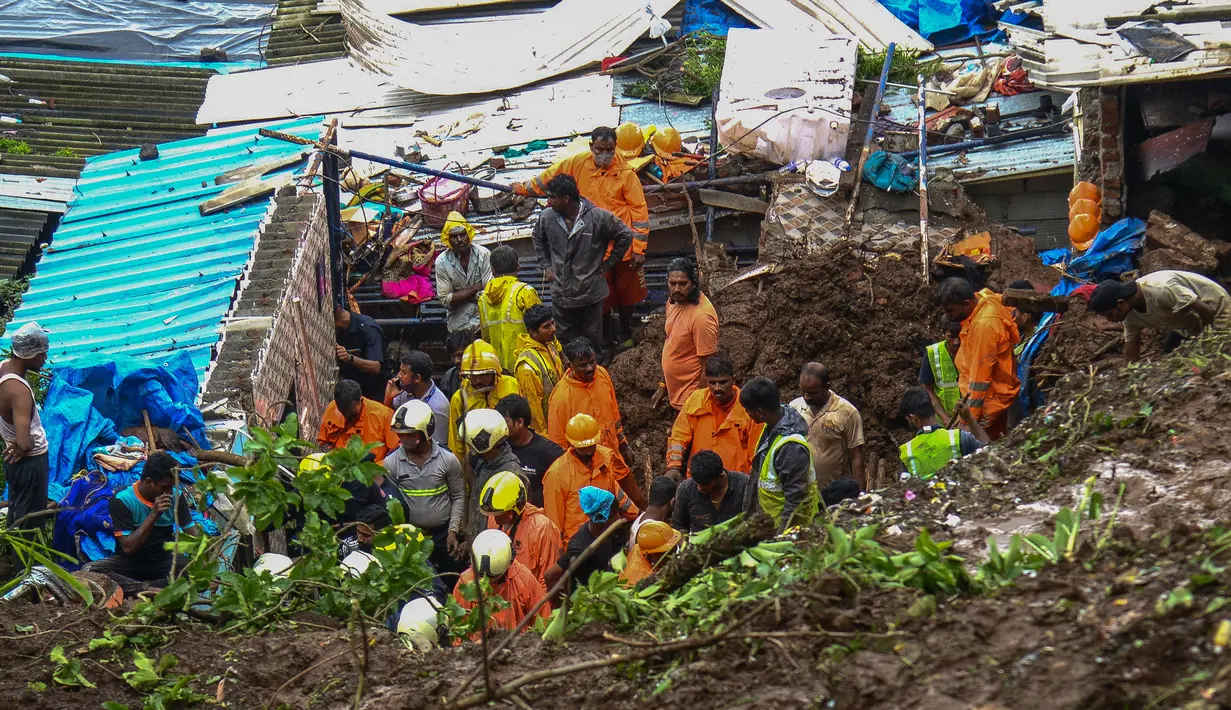 Pasukan Tanggap Bencana Nasional dan tim penyelamat lainnya memeriksa lokasi tanah longsor di daerah kumuh di Mumbai, India, Minggu (18/7/2021). Sebanyak 18 orang tewas setelah beberapa rumah hancur oleh dinding yang runtuh dan akibat tanah longsor yang dipicu oleh hujan lebat. (Sujit Jaiswal/AFP)