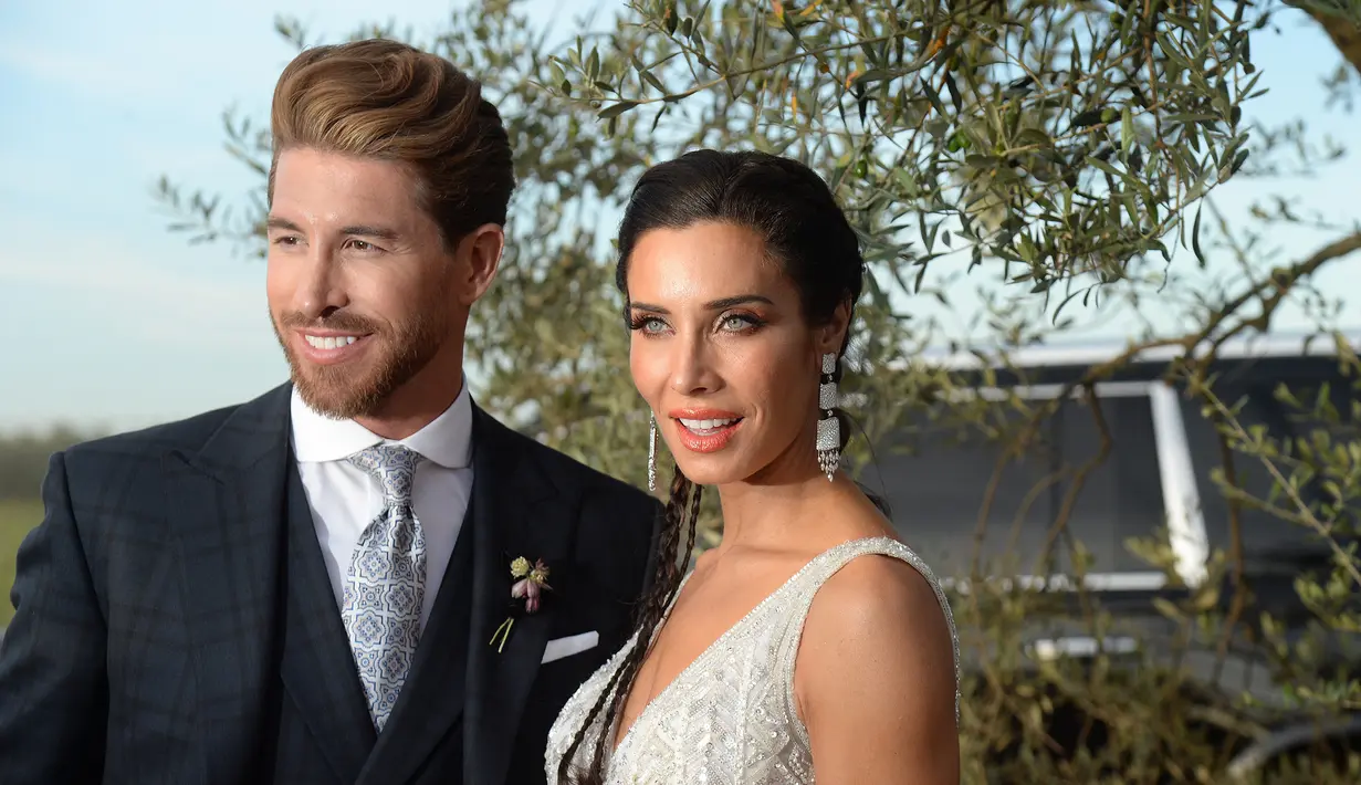 Bek Real Madrid, Sergio Ramos dan istrinya, Pilar Rubio berpose saat tiba untuk resepsi pernikahan mereka di Bollullos de la Mitacion, Sevilla, Spanyol (15/6/2019). (AFP Photo/Cristina Quicler)