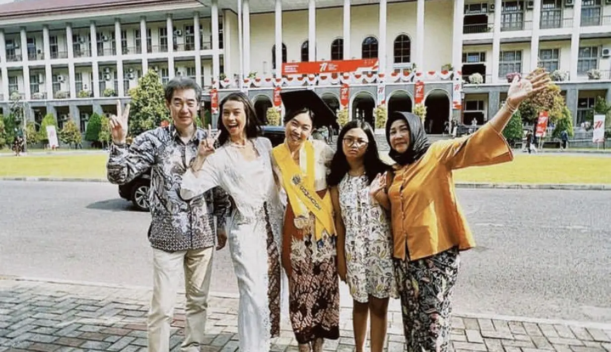 Dimomen ke lulusan sang adik, Yuki tampil dengaj kebaya panjang lace putih dipadukan kain lilit. Sedangkan sang ibu tampil dengan top orange dan kain lilitnya.  (@yukikt)