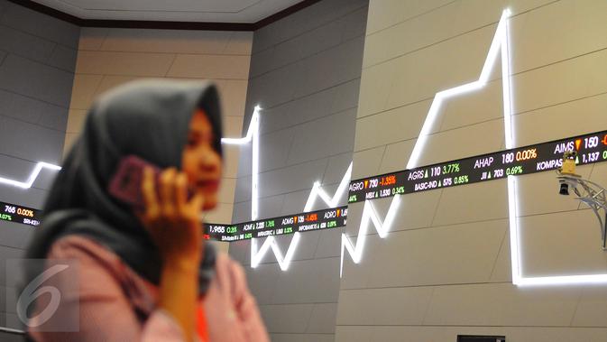 Pengunjung melintasi layar pergerakan saham di Bursa Efek Indonesia, Jakarta, Jumat (10/2). (Liputan6.com/Angga Yuniar)