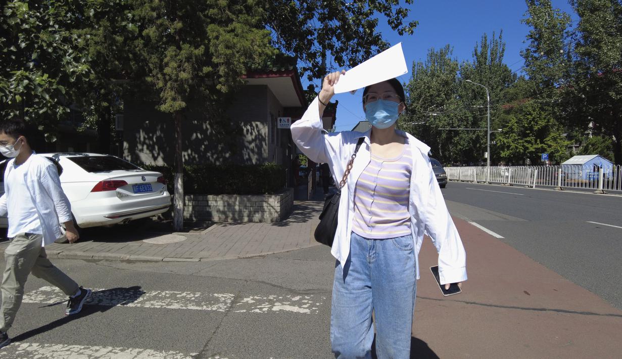 Lulusan perguruan tinggi baru-baru ini Liu Qian berjalan di sepanjang jalan di Beijing, Kamis, 7 Juli 2022. Liu adalah salah satu dari 11 juta lulusan baru yang putus asa untuk bekerja di pasar kerja yang suram karena lockdown COVID memaksa pabrik, restoran, dan pengusaha lainnya untuk tutup. Para penyintas memotong pekerjaan dan upah. (AP Photo/Olivia Zhang)