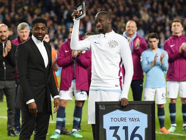Gelandang Manchester City, Yaya Toure, mendapatkan penghargaan saat perpisahan di Stadion Etihad, Rabu (9/5/2018). Laga tersebut menjadi ajang perpisahan sang pemain bersama The Citizens. (AFP/Oli Scarff)