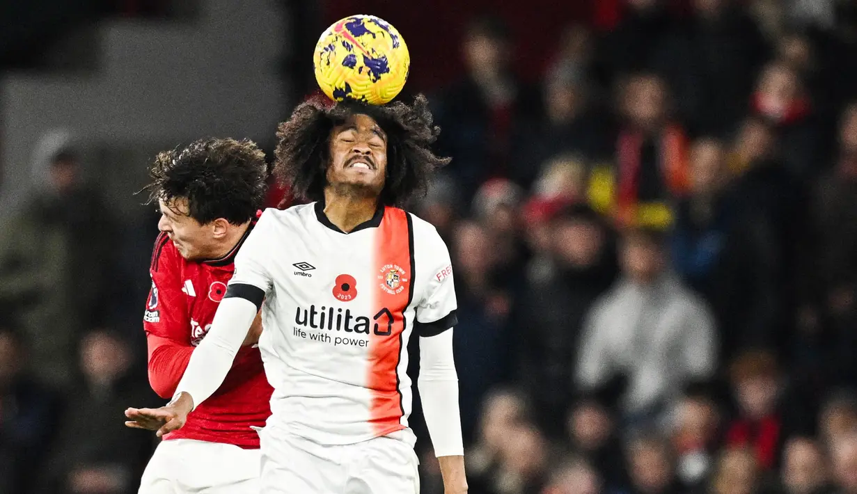 Pemain Manchester United, Victor Lindelof, duel udara dengan pemain Luton Town, Tahith Chong, pada pekan ke-12 Premier League 2023/2024 di Stadion Old Trafford, Sabtu, (11/11/2023). Berkat hasil ini, Manchester United naik ke peringkat enam klasemen sementara EPL 2023/2024. (AFP/Oli Scarff)
