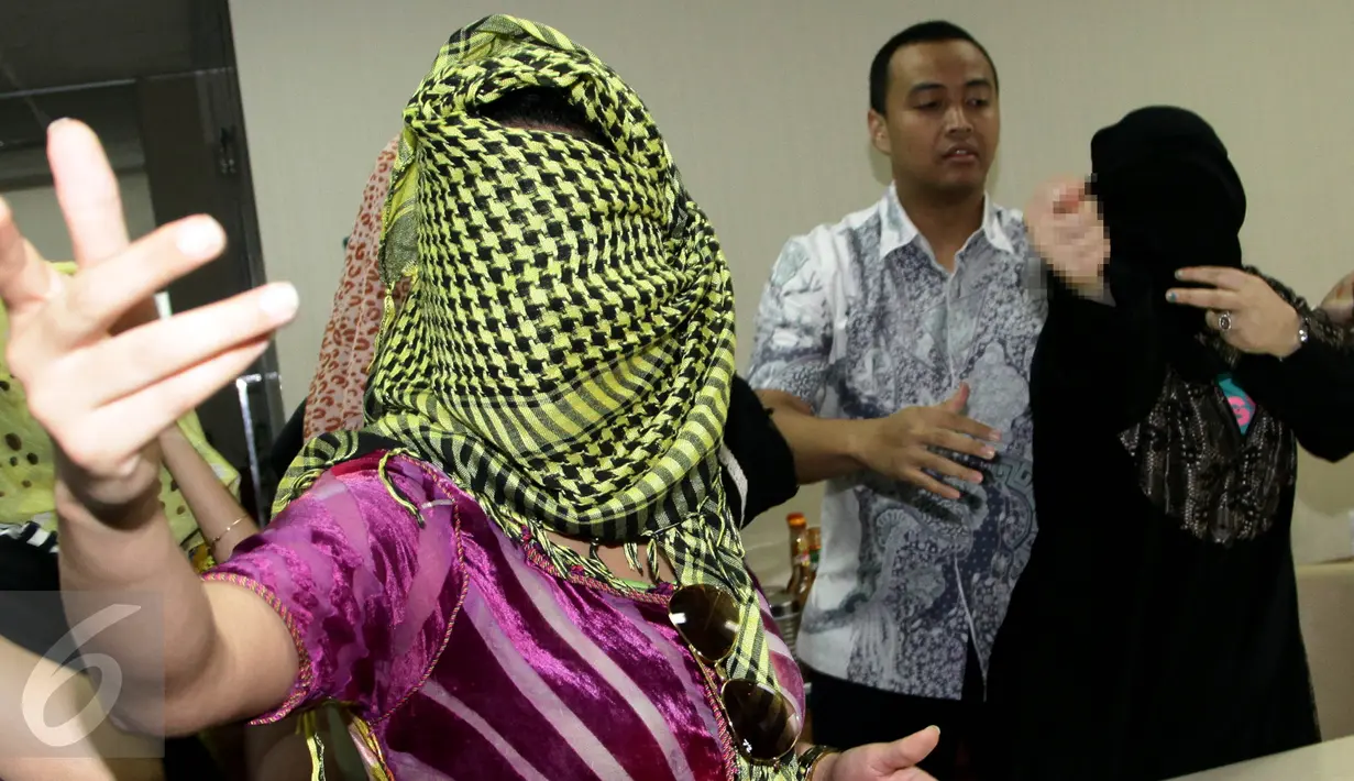 Dua wanita asal Maroko marah ketika awak media mengambil gambar dirinya di kantor Imigrasi, Jakarta, Kamis (11/6). Dalam keterangannya, pihak Imigrasi mengamankan wanita diduga PSK asal Maroko di Bogor, beberapa waktu lalu. (Liputan6.com/Johan Tallo)