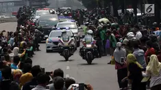 Warga antusias melihat iring-iringan mobil jenazah yang membawa almarhum Presiden ke-3 RI, BJ Habibie saat melintasi Jalan Gatot Subroto menuju TMP Kalibata, Jakarta, Kamis (12/9/2019). BJ Habibie meninggal pada Rabu (11/9/2019) setelah menjalani perawatan di RSPAD. (Liputan6.com/Johan Tallo)