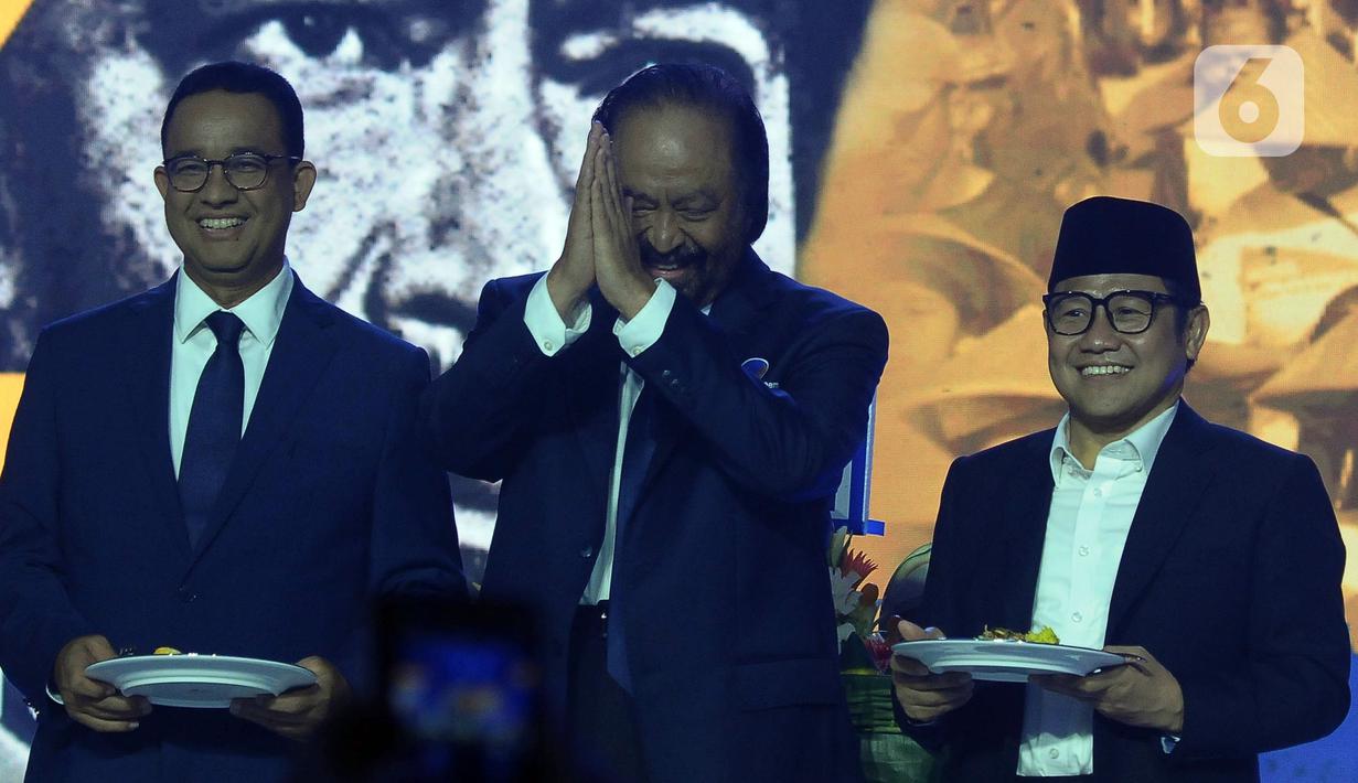 Ketua Umum Partai Nasional Demokrat (Nasdem) Surya Paloh (tengah) saat memberikan tumpeng kepada calon presiden dan calon wakil presiden Koalisi Perubahan, Anies Baswedan (kiri) - Muhaimin Iskandar (Kanan) di Kantor DPP Partai Nasdem, Jakarta, Sabtu (11/11/2023). (merdeka.com/Imam Buhori)