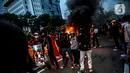 Sejumlah pendemo berswafoto di kobaran api saat aksi unjuk rasa di kawasan patung kuda, Jakarta, Selasa (20/10/2020). Gelombang protes tolak UU Cipta Kerja belum surut sejak beleid kontoversial itu disahkan pemerintah dan DPR pada 5 Oktober lalu. (Liputan6.com/Faizal Fanani)