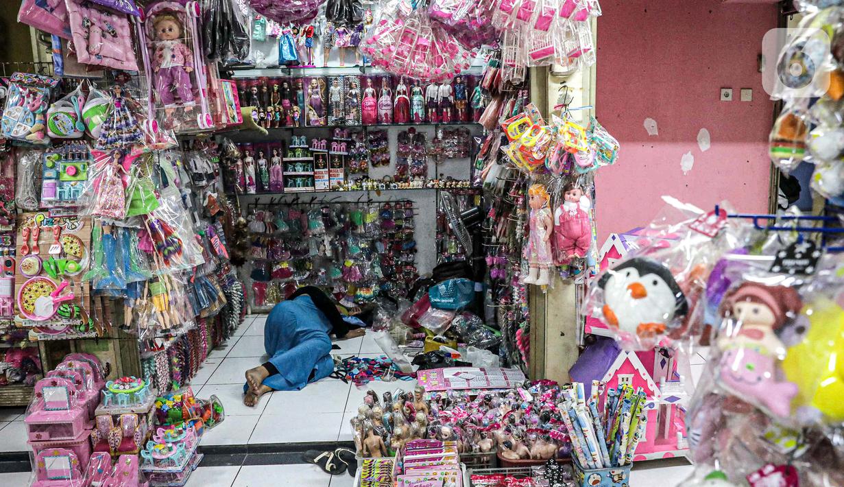 Pedagang tidur di dalam lapaknya di Pasar Gembrong Baru, Cipinang, Jakarta, Jumat (25/9/2020). Para pedagang mengatakan akibat pandemi covid-19 ini omzetnya turun hingga 80 persen, mereka pun berharap masih diperbolehkan berjualan meski PSBB Jakarta kembali diperpanjang. (Liputan6.com/Faizal Fanani)