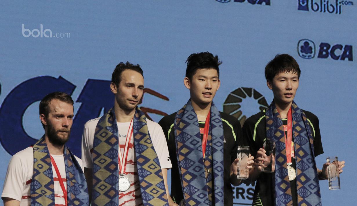 Pasangan China, Li Junhui/Liu Yuchen dan pasangan Denmark, Mathias Boe/Carsten Morgensen berada di podium. Kecerdikan dalam mengantisipasi pukulan keras Boe/Morgensen menjadi kunci kemenangan Li Junhui/Liu Yuchen. (Bola.com/M Iqbal Ichsan)