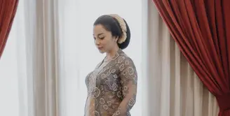 Nikita Willy tampil mengenakan kebaya lace warna keunguan berbordir bunga, dipadukan obi dan kain lilit cokelatnya. (@nikitawillyofficial94)