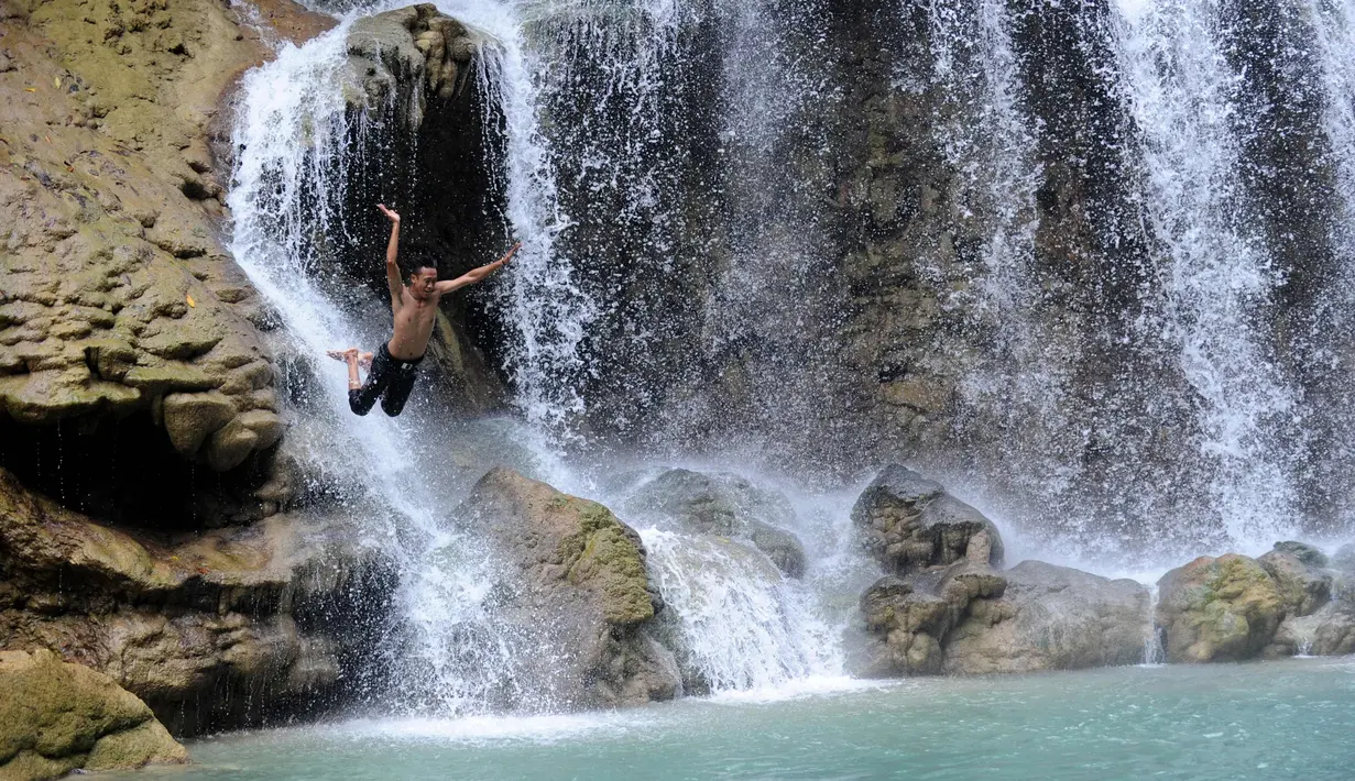 Suasana Air Terjun Lapopu yang terletak di Desa Hatikuloku, Kecamatan Wanokaka, Kabupaten Sumba Barat, Nusa Tenggara Timur (21/10). Air Terjun Lapopu memiliki kolam dengan air yang jernih kebiruan. (AFP Photo/Sony Tumbelaka)