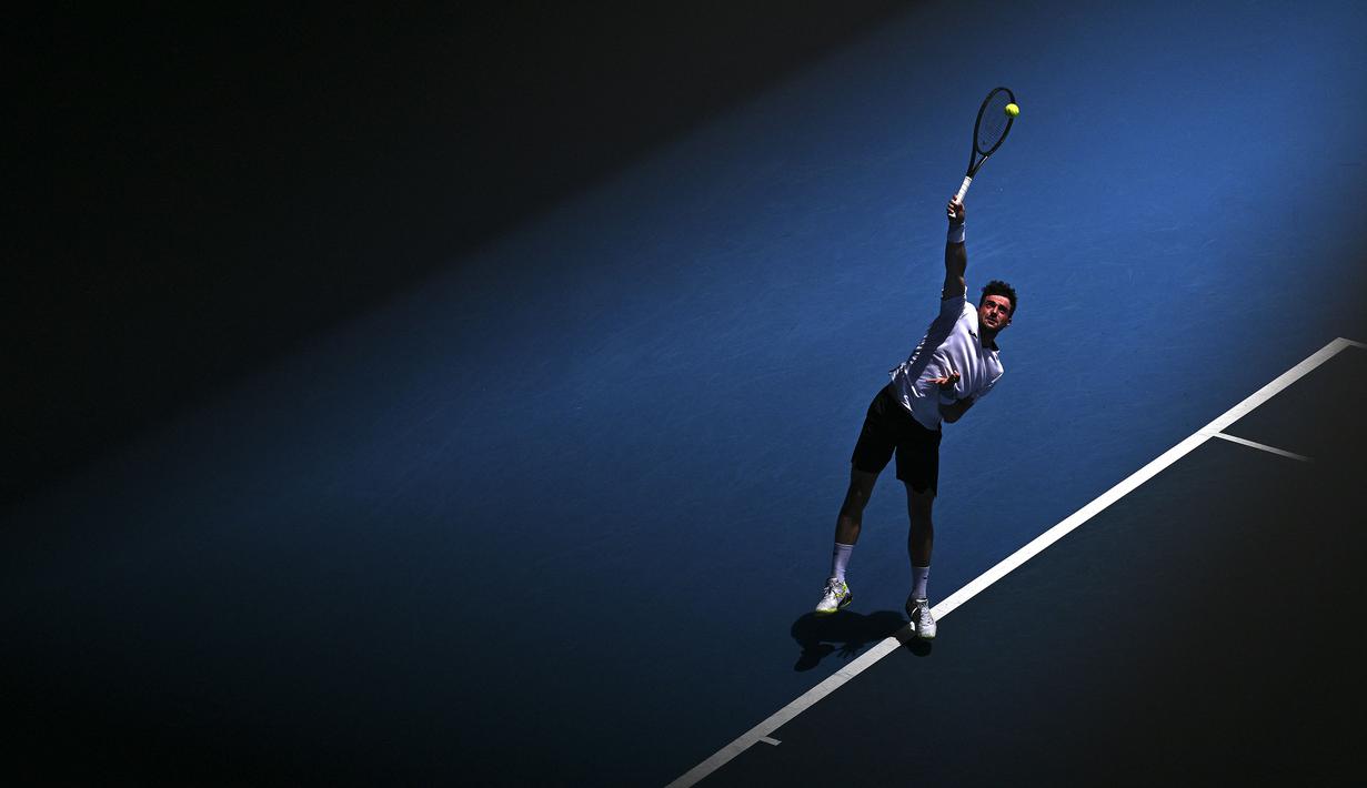 Pemain Spanyol, Pedro Martinez melakukan servis ke arah petenis Polandia, Hubert Hurkacz saat laga hari pertama Australian Open 2023 di Melbourne, Australia, Senin (16/01/2023). (AFP/Anthony Wallace)