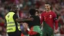 Setelah bersimpuh, sang suporter mengangkat tubuh Ronaldo dengan kedua tangannya. (Photo by CARLOS COSTA / AFP)