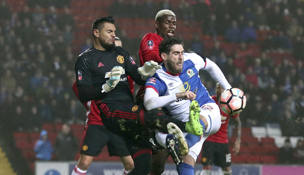 Pemain Blackburn Rovers, Danny Graham (kanan) berebut melepaskan tembakan saat dihadang kiper Manchester United, Sergio Romero dan Paul Pogba pada putaran kelima Piala FA di Ewood Park, Blackburn, (19/2/2017). (Martin Rickett/PA via AP)