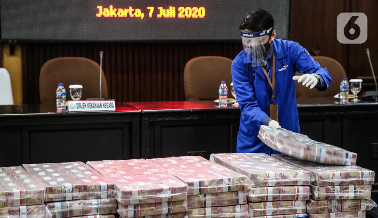 Petugas menata tumpukan uang saat rilis eksekusi barang bukti Honggo Wendratno di Kejaksaan Agung RI, Jakarta, Selasa (7/7/2020). Kejagung menyita barang bukti uang Honggo Wendratno sebesar Rp 97 miliar. (Liputan6.com/Faizal Fanani)
