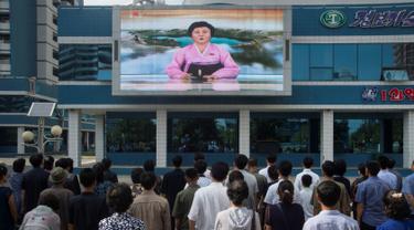  Warga menonton sebuah layar video besar di Mirae Scientists Street di Pyongyang yang menampilkan pembaca berita Ri Chun-Hee saat dia mengumumkan bahwa negara tersebut telah berhasil menguji sebuah bom hidrogen pada Senin (3/9). (AFP Photo/Kim Won-Jin)