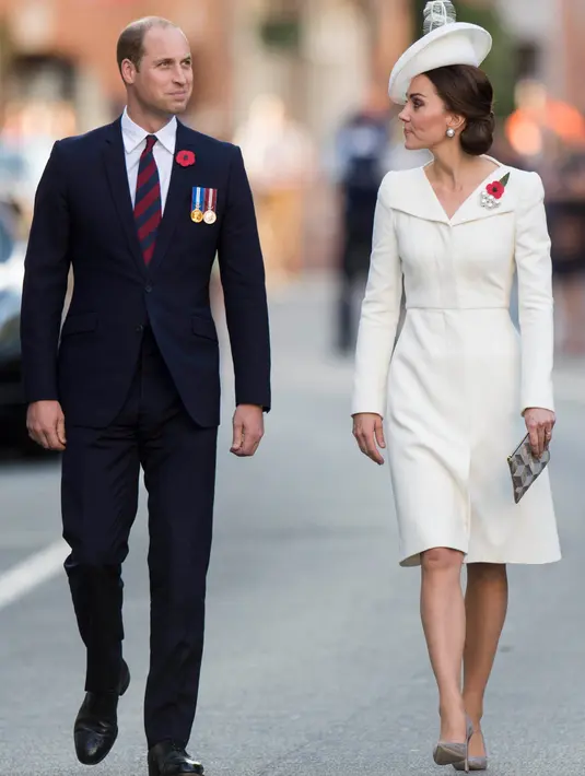 Pangeran William dan Kate Middleton menghadiri acara perayaan 100 tahun Perang Passchendaele di monumen Menin Gate, di Ypres, Belgia, Minggu (30/7). Kate memadukan coat dressnya itu dengan bross bunga poppy merah, sepatu pump dan clutch abu-abu (AP Photo)