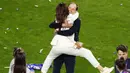 Pelatih Chelsea, Thomas Tuchel, menggendong istrinya, Sissi, saat perayaan gelar juara Liga Champions di Stadion Dragao, Porto, Minggu (30/5/2021). Chelsea menang 1-0 atas City. (Pierre Philippe Marcou/Pool via AP)