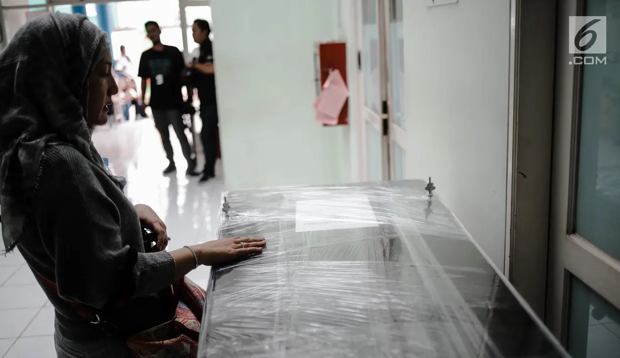 Kerabat berdoa di depan peti jenazah ibunda Roro Fitria, Raden Retno Winingsih, yang sudah dilapisi plastik wraping di RS Fatmawati, Jakarta, Senin (15/10). Jenazah ibunda Roro Fitria akan diberangkatkan ke Yogyakarta. (Liputan6.com/Faizal Fanani)