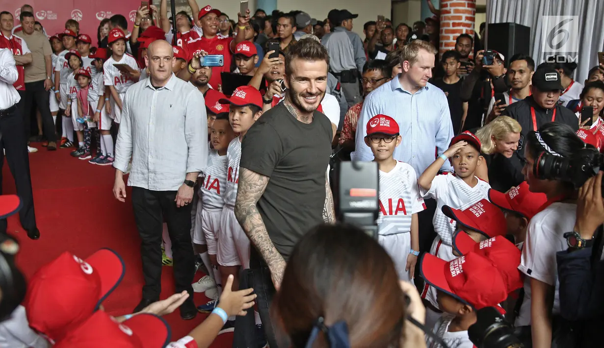 Mantan bintang sepak bola Inggris David Beckham menyapa anak-anak pada acara AIA Sepak Bola untuk Negeri di Jakarta, Minggu (25/3). David tampil di Stadion Soemantri Brodjonegoro dengan membagikan 10 ribu bola. (Liputan6.com/Herman Zakharia)