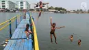 Sejumlah anak melompat saat bermain air dekat tanggul laut Muara Baru di Penjaringan, Jakarta Utara, Minggu (1/9/2019). Anak-anak memanfaatkan sisi tanggul laut raksasa (giant sea wall) sebagai   tempat  bermain alternatif. (merdeka.com/Arie Basuki)