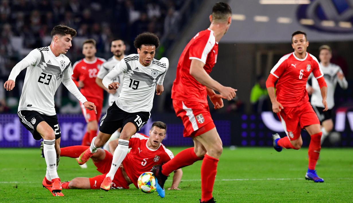Gelandang Jerman, Leroy Sane, berusaha melewati pemain Serbia pada laga persahabatan di Stadion Volkswagen, Rabu, (20/3). Jerman ditahan imbang 1-1 oleh Serbia. (AFP/Tobias Schwarz)