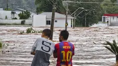 Orang-orang mengamati jalan yang banjir setelah hujan lebat di Encantado, Rio Grande do Sul, Brasil, Rabu (1/5/2024). (Photo by Gustavo Ghisleni / AFP)