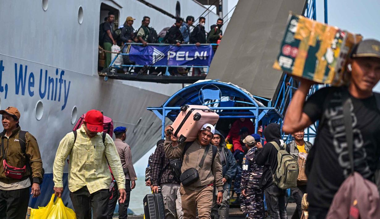 Arus mudik didominasi penumpang yang turun, kemudian melanjutkan perjalanan ke sejumlah daerah di pulau Jawa. Tampak dalam foto, para penumpang berjalan keluar untuk turun dari kapal di pelabuhan Perak, Surabaya, Jawa Timur pada Minggu 15 Maret 2026. (JUNI KRISWANTO/AFP)
