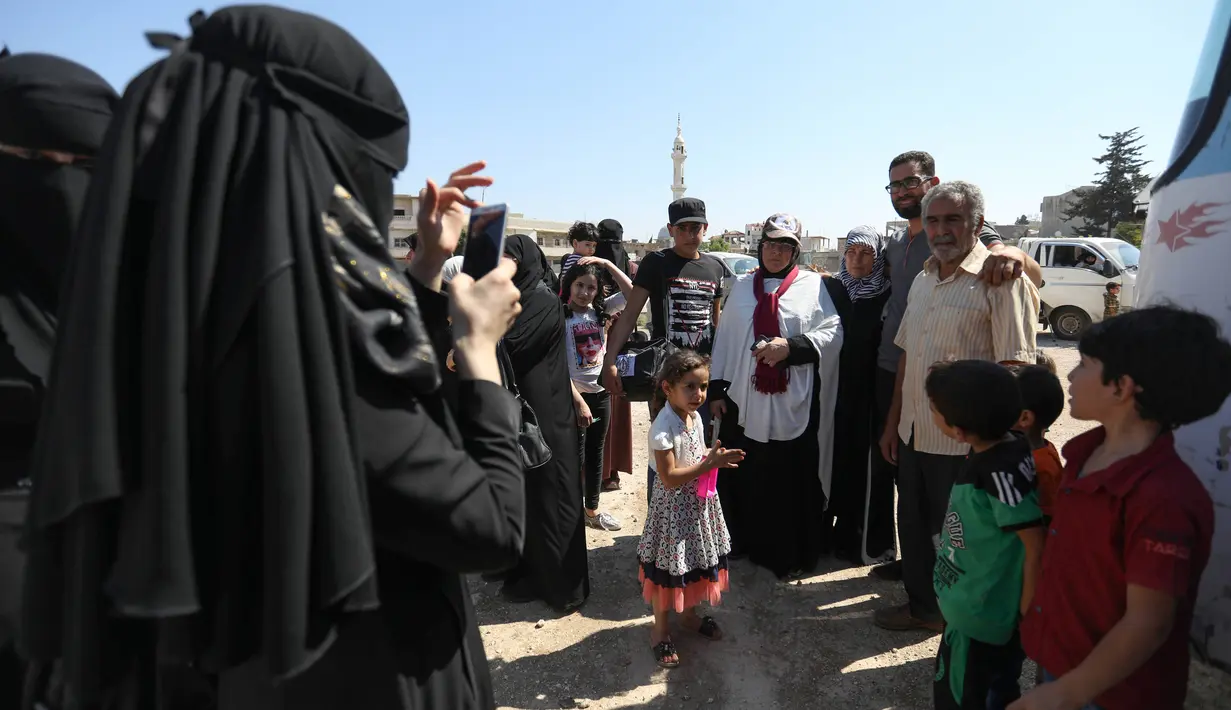 Keluarga mengantar warga Suriah dari provinsi Idlib untuk menuju Tanah Suci Makkah di kota Binnish, Senin (22/7/2019). Jemaah calon haji asal Suriah melakukan perjalanan ke Arab Saudi untuk menjalankan ibadah haji dari perbatasan Bab al-Hawa yang berseberangan dengan Turki. (Omar HAJ KADOUR/AFP)