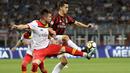 Duel pemain Benevento, Dorinel Tosca Alin (kiri) dan pemain AC Milan, Andre Silva pada laga Serie A di San Siro stadium, Milan, (21/4/2018). AC Milan kalah 0-1. (AP/Luca Bruno)