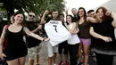 Suporter memegang jersey Juventus atas nama Cristiano Ronaldo saat merayakan transfer sang megabintang di Turin, Selasa (10/7). Juventus mendatangkan Ronaldo dengan biaya 100 juta euro atau Rp 1,68 triliun. (AFP PHOTO / Isabella Bonottovv)