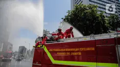 Petugas Dinas Pemadam Kebakaran Pemprov DKI melakukan penyemprotan cairan disinfektan di Jalan Thamrin, Jakarta, Selasa (31/3/2020). Penyemprotan yang dilakukan terus menerus itu untuk meminimalisir penyebaran COVID-19 di ruang udara dan ruas jalan. (Liputan6.com/Faizal Fanani)