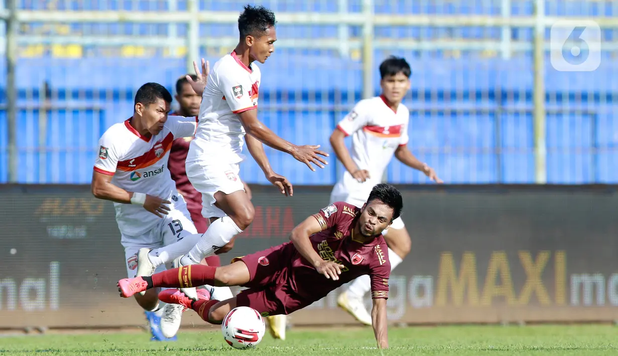 Pemain PSM Makassar, Saldy, terjatuh saat berebut bola dengan pemain Borneo FC Samarinda, Hendro Siswanto, pada laga Piala Menpora 2021 di Stadion Kanjuruhan, Malang, Rabu (31/3/2021). Borneo FC berhasil menahan imbang 2-2 saat menghadapi PSM Makassar. (Bola.com/M Iqbal Ichsan)
