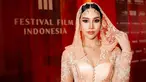 Dalam balutan kebaya warna peach, Anya Geraldine memukau penonton dengan penampilan menawan di red carpet FFI 2023 berkat kerudungnya. Kebaya rancangan Eddy Betty dan kain batik menjadi pilihan yang sempurna, dipadukan dengan kain kerudung senada. (Liputan6.com/IG/@anyageraldine)