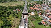 Foto udara memperlihatkan kemacetan yang terjadi dalam Tol Tangerang-Merak, Banten, Jumat (29/4/2022). Kemacetan sepanjang 7 Kilometer mengular hingga ke dalam tol akibat lonjakan pemudik yang hendak menyeberang ke Pulau Sumatera melalui Pelabuhan Merak. (Liputan6.com/Angga Yuniar)