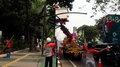 Petugas Suku Dinas PE Jakarta Pusat bersama Satgas PJU, mencabut dan menggeser tiang listrik dan lampu penerangan jalan yang menghalangi jalur sepeda di trotoar Jalan Asia Afrika dan Jalan Gelora, Senayan, Jakarta, Rabu (1/8). (Liputan6.com/Johan Tallo)