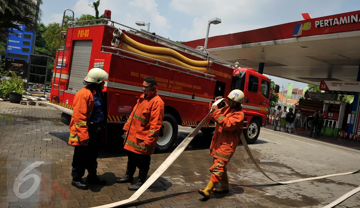 Petugas pemadam kebakaran menarik selang yang digunakan untuk memadamkan kebakaran di SPBU Abdul Muis, Jakarta, Senin (12/9). Akibat kebakaran tersebut, SPBU ditutup sementara sampai menunggu penyelidikan lebih lanjut. (Liputan6.com/Gempur M Surya)