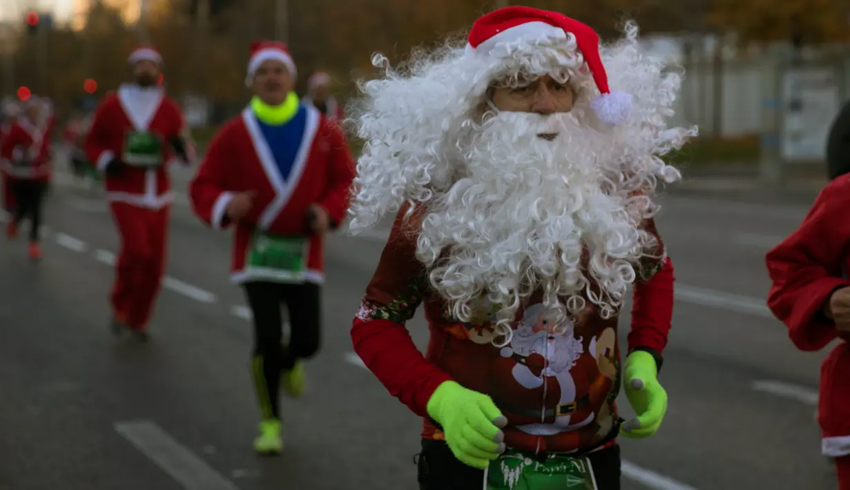 Pelari mengenakan kostum Sinterklas ambil bagian dalam Santa Claus Run di Madrid, Spanyol, Minggu (9/12). Ribuan memeriahkan acara yang sudah diselenggarakan sejak 7 tahun yang lalu. (AP/Emilio Morenatti)