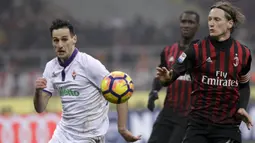 Penyerang Fiorentina, Nikola Kalinic, berebut bola dengan bek AC Milan, Ignazio Abate. Pada laga ini Milan turun menggunakan formasi 4-3-3, sementara Fiorentina memakai skema 3-4-2-1. (AP/Antonio Calanni)