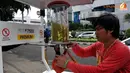 Kios yang dibuat menggunakan drum yang disambungkan dengan pompa manual untuk menaikkan bensin lalu ditampung dalam tabung khusus (Liputan6.com/Johan Tallo).