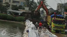 Alat berat dikerahkan untuk membuat tanggul untuk mencegah banjir di kawasan Perumahan Pantai Mutiara, Jakarta, Sabtu (4/6). Akibat tanggul jebol kawasan tersebut tergenang dengan ketinggian 50-60 sentimeter. (Liputan6.com/Gempur M Surya)