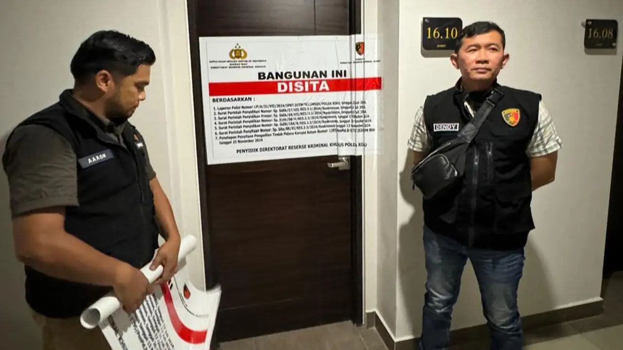 Pemasangan tanda penyitaan apartemen di Batam terkait dugaan korupsi SPPD fiktif di DPRD Riau.