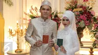 Pasangan Artis, Ben Kasyafani dan Nesyana Ayu Nabila berpose sambil memegang buku nikah usai ijab kabul di  kawasan Mega Kuningan, Jakarta, Sabtu (30/07). (Liputan6.com/Herman Zakharia)