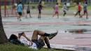 Seorang warga beristirahat usai olahraga di Kawasan Monumen Nasional, Jakarta, Rabu (13/2). Monas merupakan salah satu lokasi yang kerap dijadikan ruang olahraga bagi warga ibukota. (Bola.com/M. Iqbal Ichsan)