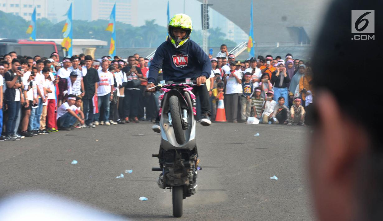 Freestyler melakukan atraksi freestyle sepeda motor saat memeriahkan Festival Damai Millenial Road Safety di Monas, Jakarta, Minggu (23/6/2019). Festival ini juga dimeriahkan oleh berbagai atraksi dan pertunjukan musik artis Tanah Air. (merdeka.com/Iqbal Nugroho)