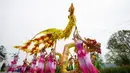 Warga desa mengenakan kostum tradisional ambil bagian dalam pertunjukan rakyat di Distrik Tongliang, China (19/9/2020). Pertunjukan tari naga dan kegiatan rakyat lainnya digelar untuk merayakan festival panen petani China yang jatuh pada Equinox Musim Gugur setiap tahunnya. (Xinhua/Liu Chan)