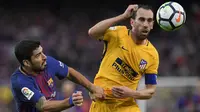 Bek Atletico Madrid, Diego Godin, duel udara dengan striker Barcelona, Luis Suarez, pada laga La Liga Spanyol di Stadion Camp Nou, Barcelona, Minggu (4/3/2018). Barcelona menang 1-0 atas Atletico. (AFP/Lluis Gene)