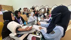 Petugas memeriksa kesehatan calon haji setibanya di Asrama Haji Pondok Gede, Jakarta, Selasa (21/4/2026). Sebanyak 393 jemaah haji kelompok terbang (kloter) pertama embarkasi Jakarta-Pondok Gede (JKG 01) secara resmi mulai memasuki Asrama Haji Pondok Gede, Jakarta Timur. (merdeka.com/Arie Basuki)