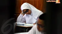 Salah satu siswi SMA 65 Jakarta, terlihat begitu serius membaca soal- soal ujian nasional hari pertama pada Senin 14 April 2014. (Liputan6.com/JohanTallo)
