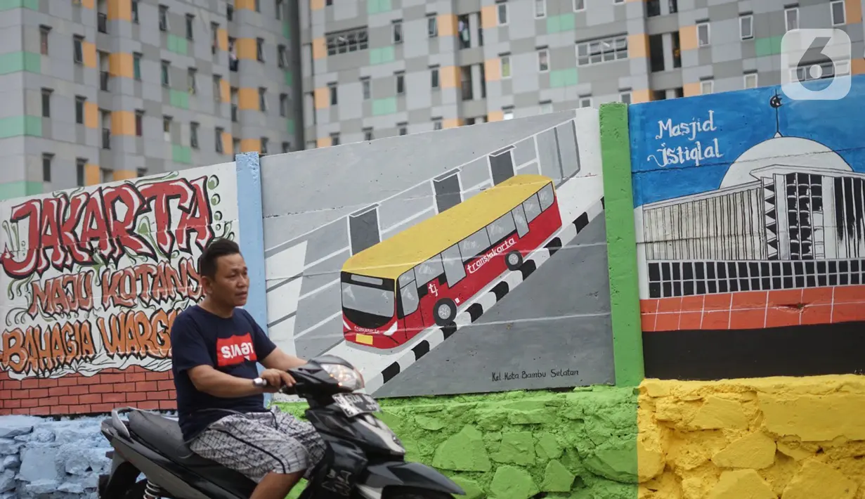 Pengendara motor melintas di depan mural bertema Kota Jakarta di sekitar Rusunawa KS Tubun, Jakarta, Senin (23/11/2020). Mural tersebut dibuat guna memercantik lingkungan di sekitar rusun agar lebih berwarna dan tidak tampak kumuh. (Liputan6.com/Immanuel Antonius)